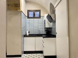 a kitchen with white cabinets and a sink at Apartamento Plaza del Cabildo II - Sanlúcar Centro in Sanlúcar de Barrameda +7 photos