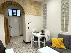 a living room with a table and chairs and a couch at Apartamento Plaza del Cabildo II - Sanlúcar Centro in Sanlúcar de Barrameda