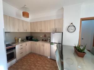 a kitchen with a refrigerator and a clock on the wall at Elbasan center apartment in Elbasan