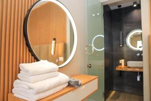 a bathroom with a mirror and a pile of towels at Luna Mare Boutique Seaside in Borsh