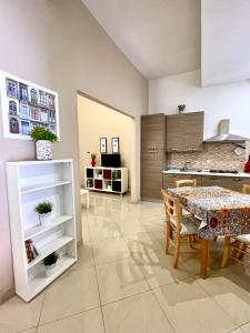 ein Wohnzimmer mit Tisch und Küche in der Unterkunft Ciraulo Apartment Central Old Town Catania in Catania + 9 Fotos