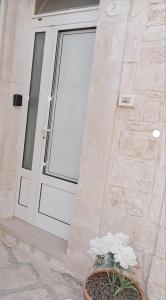 une porte d'un bâtiment avec une usine de pot à côté de celui-ci dans l'établissement La Casetta di Francy, à Martina Franca