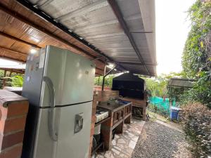 an outdoor kitchen with a refrigerator and a grill at Finca el Morichal in Buga