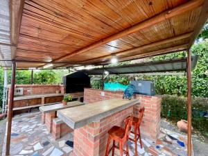 a patio with a table and chairs under a wooden pergola at Finca el Morichal in Buga