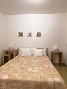 ein Bett in einem Schlafzimmer mit zwei Tischen und zwei Bildern an der Wand in der Unterkunft Ciraulo Apartment Central Old Town Catania in Catania