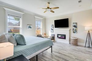 a living room with a bed and a flat screen tv at Steps to Beach Modern Gulfport Getaway! in Gulfport