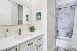 a white bathroom with a sink and a shower at Steps to Beach Modern Gulfport Getaway! in Gulfport +19 photos