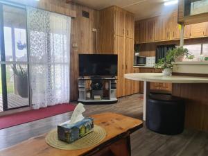 a living room with a tv and a table at White Cliff Farm House in Mildura