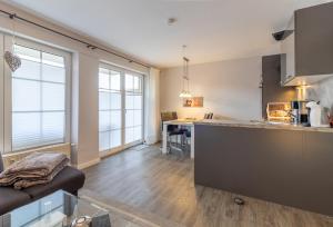 a kitchen and a living room with a couch at Ferienwohnung Ebbe in Hooksiel