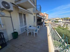 a patio with a table and chairs on a balcony at Appartamento Mare in San Benedetto del Tronto