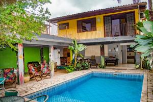 a villa with a swimming pool in front of a house at Hostel Morada do sol Paraty in Paraty