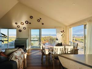 a living room with a couch and a table with a fireplace at Sailor's Catch in Hokitika