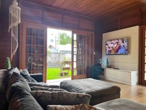 邦比尼亚斯B167 - Casa de Alto Padrão com Piscina Privativa e Espaço Gourmet a 450m do Mar na Praia de Mariscal - Bombinhas-SC的带沙发和电视的客厅