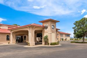a building with a clock tower in a parking lot at Best Western Moriarty Heritage Inn in Moriarty