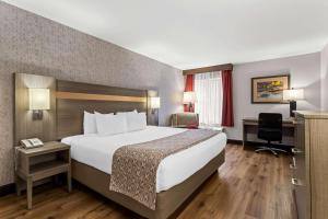 a hotel room with a large bed and a desk at Best Western Moriarty Heritage Inn in Moriarty +23 photos
