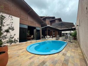 邦比尼亚斯B167 - Casa de Alto Padrão com Piscina Privativa e Espaço Gourmet a 450m do Mar na Praia de Mariscal - Bombinhas-SC的露台中央的游泳池