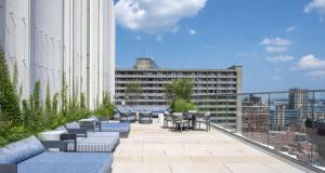 a rooftop patio with tables and chairs on a building at Back-Bay 2BR Condo w Roof top Gym Parking in Boston