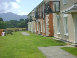 Une rangée de bâtiments avec une cour en herbe à côté d'eux dans l'établissement Killarney Self Catering - Rookery Mews Apartments, à Killarney