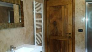 a bathroom with a sink and a wooden door at Maison de Vittor - Cogne in Cogne +9 photos