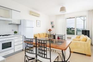 eine Küche und ein Wohnzimmer mit Tisch und Stühlen in der Unterkunft Mountain & Seaview Penthouse in a Holiday Village2 in Ayios Yeoryios