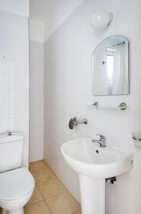 ein weißes Badezimmer mit Toilette und Waschbecken in der Unterkunft Mountain & Seaview Penthouse in a Holiday Village2 in Ayios Yeoryios