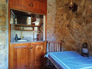 a kitchen with a sink and a counter with a table at Moinho da Alfazema in Penacova +19 photos