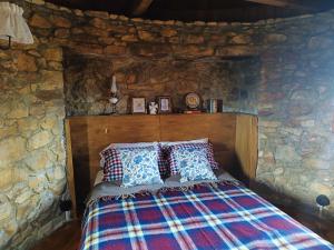 a bedroom with a bed in a stone wall at Moinho da Alfazema in Penacova