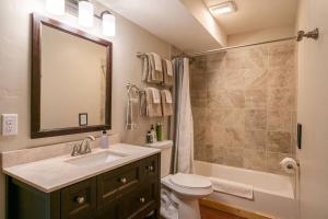 a bathroom with a sink and a toilet and a mirror at Alpine Lodge - Epic Mountain Views, Hot Tub, 2 Miles to Town in Leavenworth +38 photos