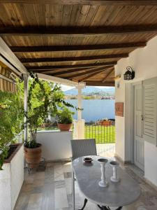 a patio with a table and a view of the water at Marias Apartments in Vasiliká