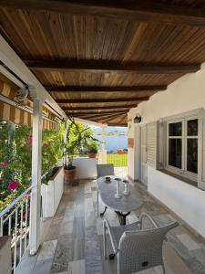 a patio with a table and chairs under a wooden ceiling at Marias Apartments in Vasiliká