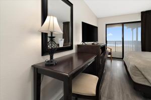 a bedroom with a desk with a bed and a mirror at Eden Roc Ocean Front in Ocean City