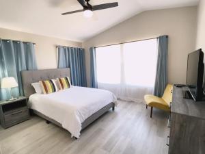a bedroom with a bed and a television and a window at Pool House Newly Remodeled 3bed 3bath Near DT Summerlin and Red Rock in Las Vegas
