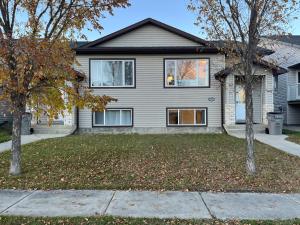 una casa con dos árboles delante de ella en Park View Paradise - Big, Bright, Modern, Fully Stocked, en Grande Prairie