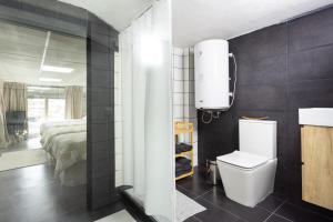 a bathroom with a toilet and a bedroom at OkStay Loft Victoria Top Tenerife in La Victoria de Acentejo