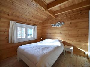 a bedroom with a bed in a log cabin at ZeeWolf in Sint Annaland