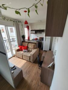 a kitchen and living room with a couch and a table at AP BOHO 1010 Brás - Piscina Aquecida, WiFi, Academia, Cama Casal box e colchão extra solteiro in Sao Paulo +47 photos