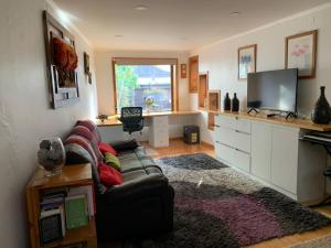 a living room with a couch and a television at Casa familiar 4 habitaciones Pichilemu in Pichilemu