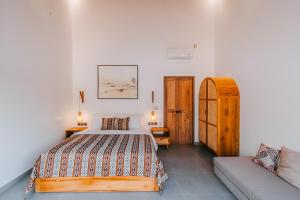 a bedroom with a bed and a couch at Villa Diamond Lembongan in Nusa Lembongan