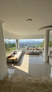 a living room with couches and a view of the city at Mansão da Montanha in Niterói