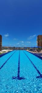 a large swimming pool with blue water at VG Fun Beach Front Apartamentos in Fortaleza