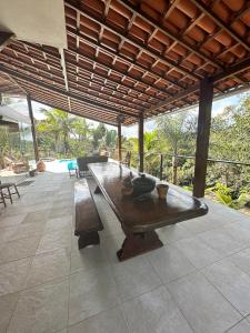 Casa Dendê - Arraial D'Ajuda في ارايال دايودا: طاولة خشبية كبيرة على الفناء