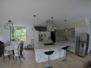 a kitchen with a table and chairs and a refrigerator at Finca Terraviva Hermoso Paraíso Natural in Moniquirá