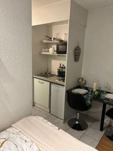 a small kitchen with a desk and a bed in a room at La belle étape et Parking in Carquefou
