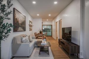 尖竹汶Sunstone Villa Chanthaburi的客厅里有一张沙发和一台电视