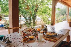 a table with plates of food and drinks on it at RIAD AMAN SKOURA in Skoura