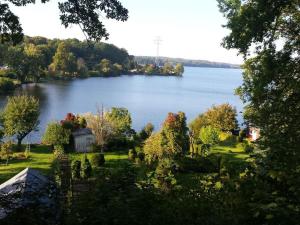 a view of a lake with trees and a house at Holiday apartment in Waren Müritz in Waren