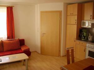 a living room with a red couch and a kitchen at Holiday Apartment, Apartment Melanie in Niederthai