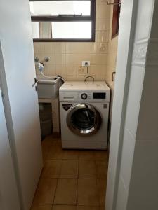 a small bathroom with a washing machine in it at Casa Estivariz Madryn in Puerto Madryn