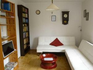 a living room with a white couch with a red pillow at Wiete Lenk Comfortable holiday residence in Dresden