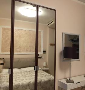 a mirror in a bedroom with a bed and a lamp at Hotel Martin in Volpiano